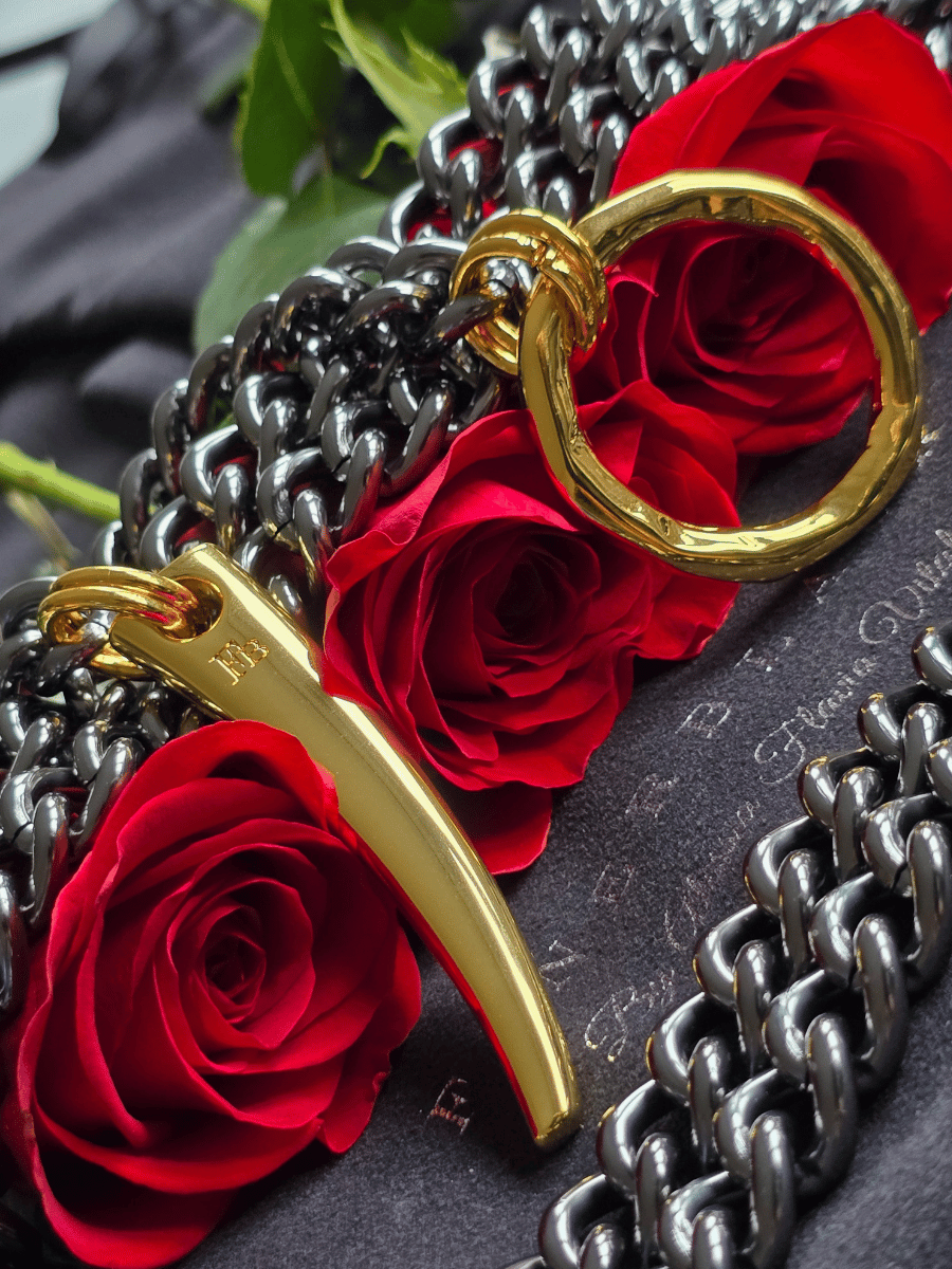 body chain necklace with o ring and spike detail on red roses