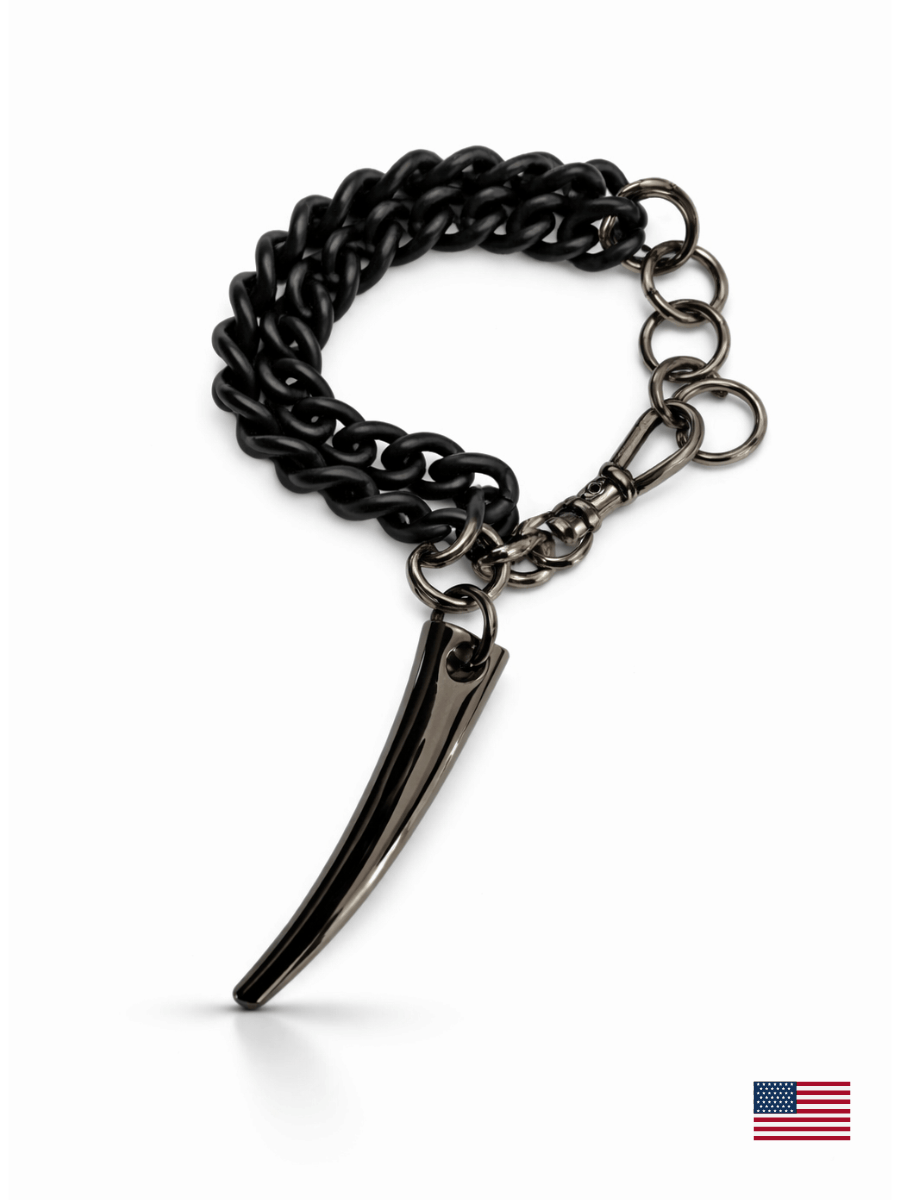 Black chain bracelet with a unique fang pendant on a white background