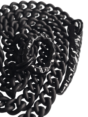 Black chain necklace detail of shiny black oval and claw on white background