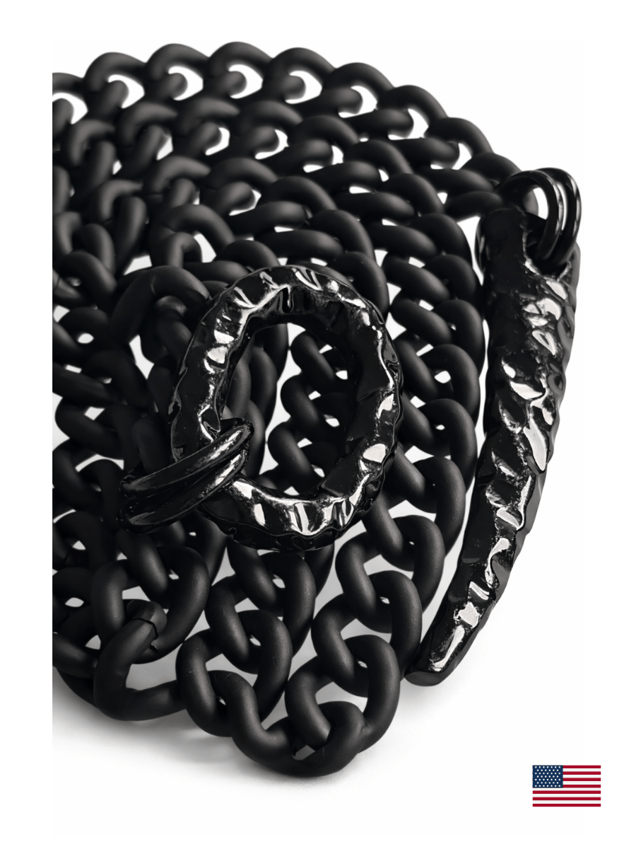 Black on black chain necklace with a hammered O ring and claw pendant  on a white background