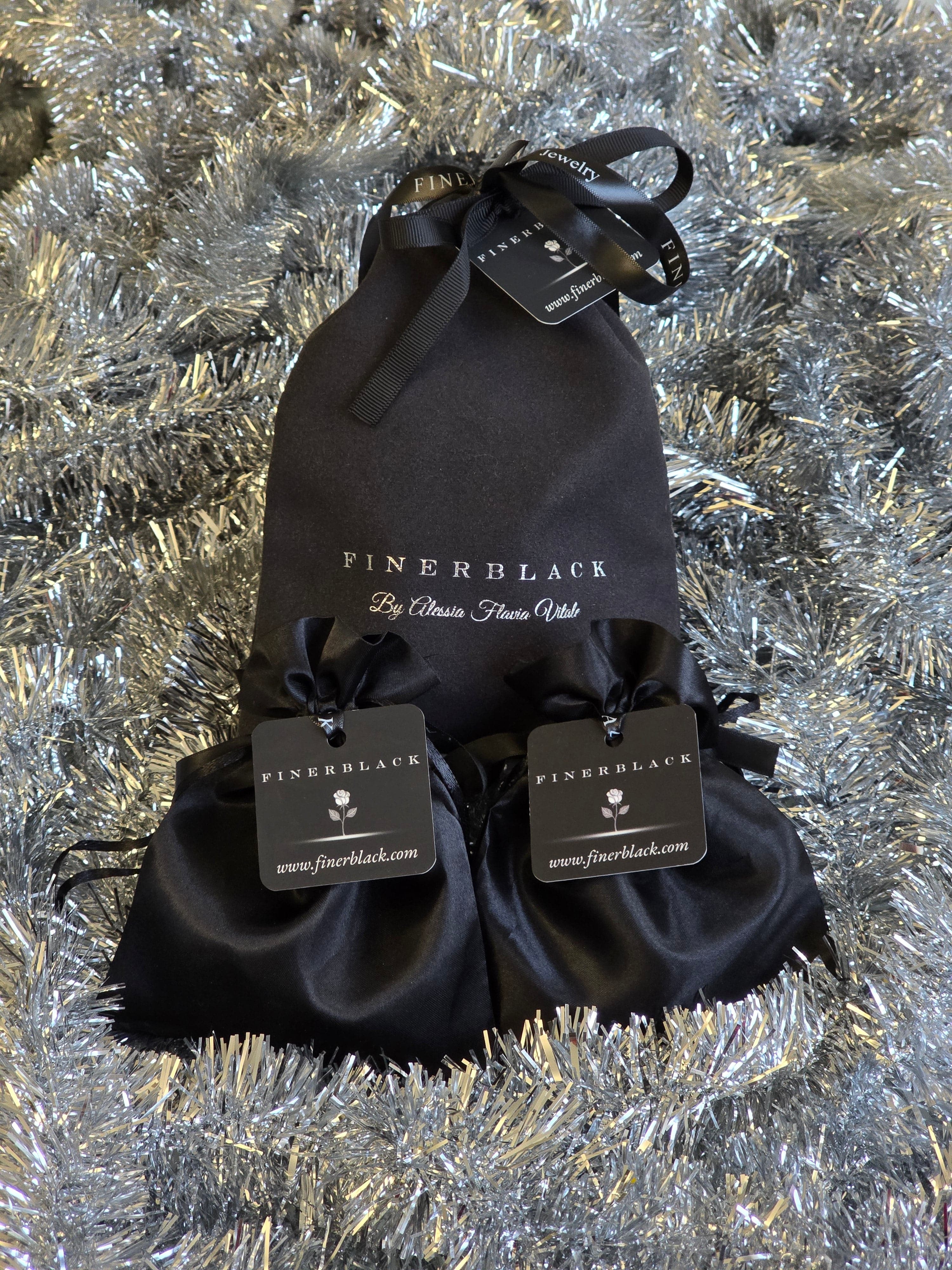 Black drawstring bags with brand tags on a textured silver background