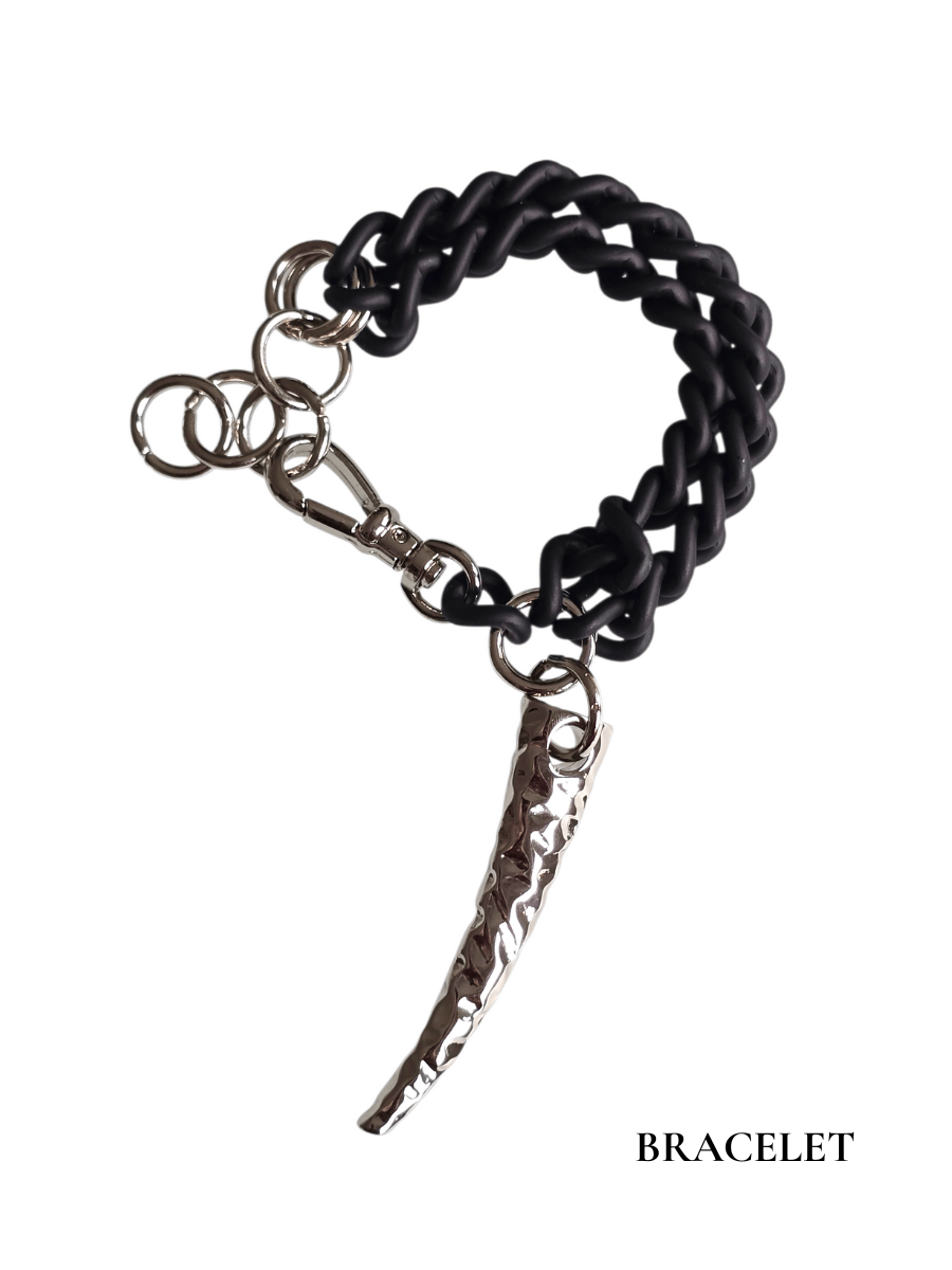 Black chain bracelet with a silver dagger charm on a white background